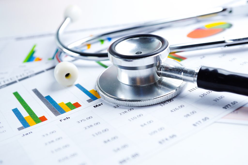 Stethoscope and financial tables and graphs representing the Health Economics and Outcomes Research projects that Columbia Data Analytics focuses on.